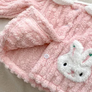 Close-up of pink fleece pajamas with a cute plush rabbit head and white buttons