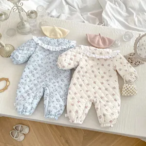 Detail of floral quilted baby rompers featuring lace collars and soft textured fabric