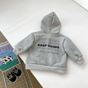Close-up of gray kids' hoodie featuring black Keep Going lettering and ribbed cuffs