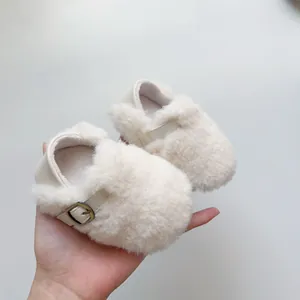 Detailansicht der flauschigen Babyschuhe in Beige mit Metallschnalle und weichem Kunstfell