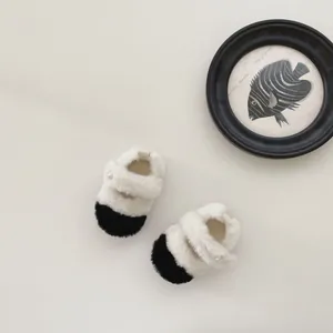 Vue détaillée des chaussures bébé en peluche avec boucle perle et texture fourrure