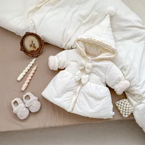Detail der weißen Baby-Kapuzenjacke mit großen Schleifen und flauschigem Plüschbesatz