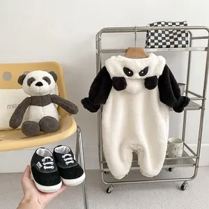 Dettaglio della tutina a panda in pile bianco con scarpine in tela nere da neonato