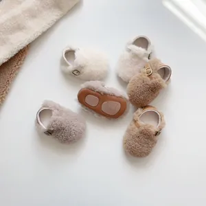 Detail von Plüsch-Babyschuhen mit rutschfesten braunen Sohlen und Bärenmuster