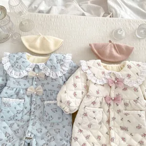 Detail view of floral quilted baby rompers with lace collars and ribbon bows