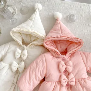 Detail von süßen Wintermänteln für Kleinkinder mit Schleifen und Rüschen in Rosa und Beige