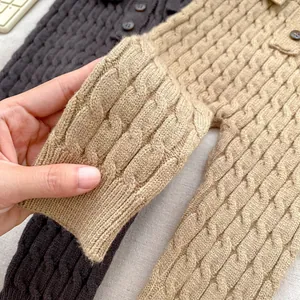 Detalle de mameluco de punto para bebé con botones de madera y puños acanalados suaves