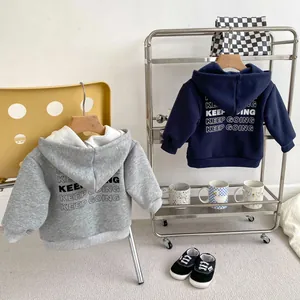 Detail view of fleece hoodies in grey and navy blue with KEEP GOING back print for boys