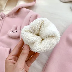 Detailed close-up showing soft white lamb wool lining inside a pink baby rabbit hoodie