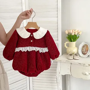 Close-up of red baby romper featuring white doll collar and delicate lace embroidery