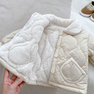 Dettaglio tutina neonato beige trapuntata con calda fodera in pile e bottoni