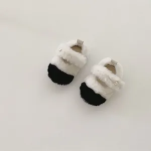 Détail de chaussures de marche bébé en peluche avec fourrure blanche et boucle perle