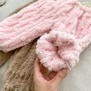 Detailed close-up of thick coral fleece pajamas showing warm fabric texture and cuffs