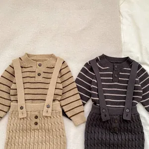 Detalle del suéter de rayas para bebé y pantalones de tirantes con trenzado