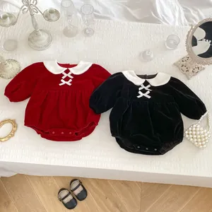 Detailed view of red and black velvet baby bodysuits with white collars and lace-up ribbons