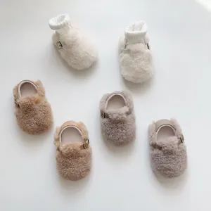 Nahaufnahme von flauschigen Babyschuhen in Creme, Camel und Taupe mit Riemchen