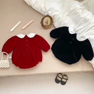 Detailed close-up of velvet baby bodysuits with Peter Pan collars in red and black