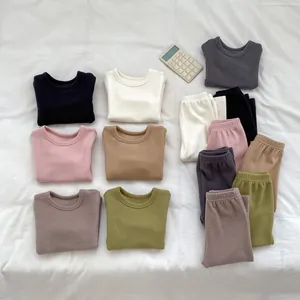 Flat lay of soft thermal children's loungewear sets in seven earthy Morandi colors