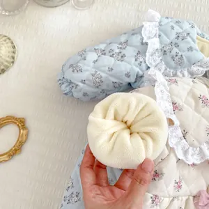 Detail of floral baby bodysuit with lace trim and soft fleece lining for warmth