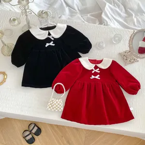 Flat lay of velvet princess dresses in red and black with Peter Pan collar and bows