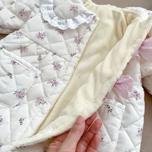 Detail of floral baby bodysuit featuring warm fleece lining and delicate lace collar