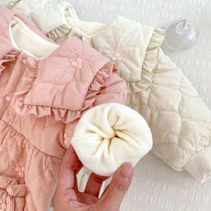 Detail of embroidered floral patterns and thick fleece lining on baby winter romper