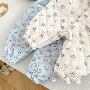 Detailed view of quilted floral baby trousers with ribbed cuffs and snap button closure
