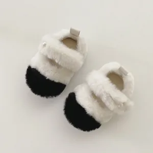 Détail de la chaussure pelucheuse pour bébé avec fausse fourrure et décor de perle