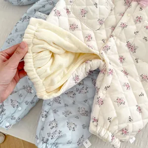 Detailed macro view of quilted floral baby romper showing thick warm fleece lining texture