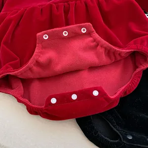 Detail view of baby red velvet romper featuring three durable white resin snap fasteners