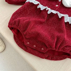Detail of red baby romper showing silver glitter texture and white lace collar details