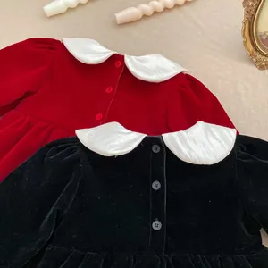 Detail view of red and black velvet baby rompers with white vintage doll collars and buttons