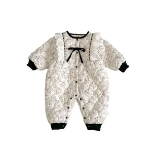 Quilted floral baby romper with black bow and lace trim in off-white winter style