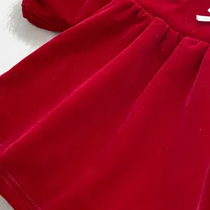 Close-up of red velvet girl dress showing rich fabric texture and waist pleat detail