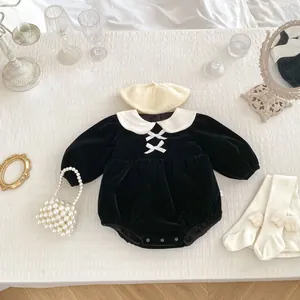 Close-up of velvet baby romper with bows, pearl bag, beret, and winged socks set