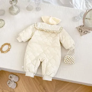 Detail of quilted winter baby romper with floral embroidery and ruffle collar plus beret