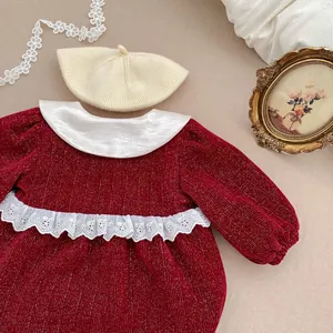 Detail of baby winter red dress with white lace trim and cream knit beret hat