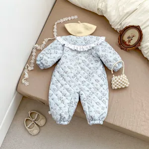 Detail of baby floral bodysuit featuring quilted fabric and elegant lace collar trim