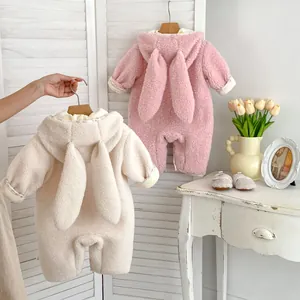 Close-up of thick fleece baby rompers with cute rabbit ears in pink and beige colors