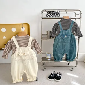 Détail de salopettes en jean pour bébé et t-shirts rayés montrant les boutons et tissus