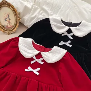 Detailed flat lay of velvet toddler dresses with white Peter Pan collars and bows