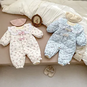Detailed view of floral quilted baby rompers with lace collars and bow accents
