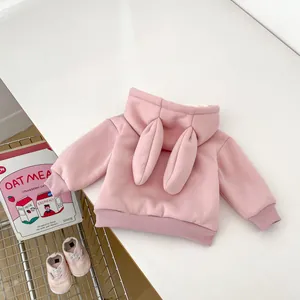 Detail of pink fleece baby hoodie with plush rabbit ears on the hood and ribbed cuffs