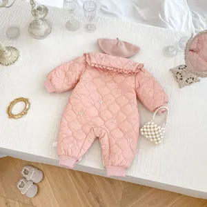 Detail of baby quilted romper with floral embroidery and ruffle collar and matching hat