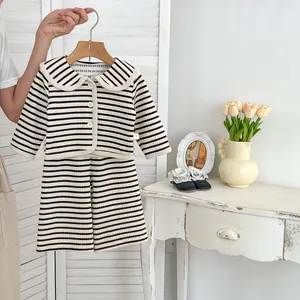 Détail d'un haut rayé noir et blanc pour fille avec col Peter Pan et boutons blancs