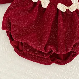 Detail von rotem Baby-Body mit glitzerndem Stoff und weißen Satinschleifen