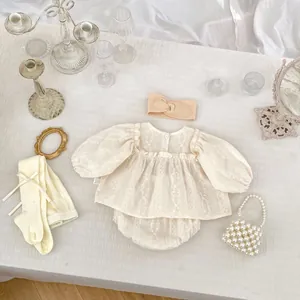 Détail à plat de l'ensemble bébé avec chemise à broderie florale, short et bandeau