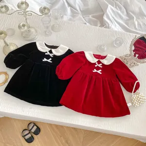 Detailed view of red velvet baby princess dress with white Peter Pan collar and bow