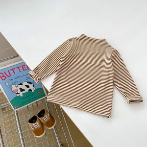 Détail d'un t-shirt rayé en coton pour bébé aux couleurs marron et blanc pour le printemps