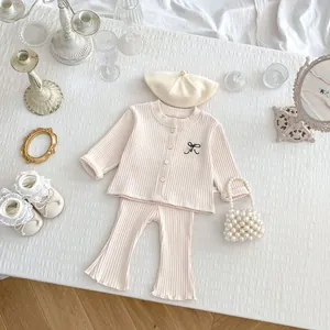 Close-up of baby ribbed knit cardigan with bow embroidery and matching flared pants set